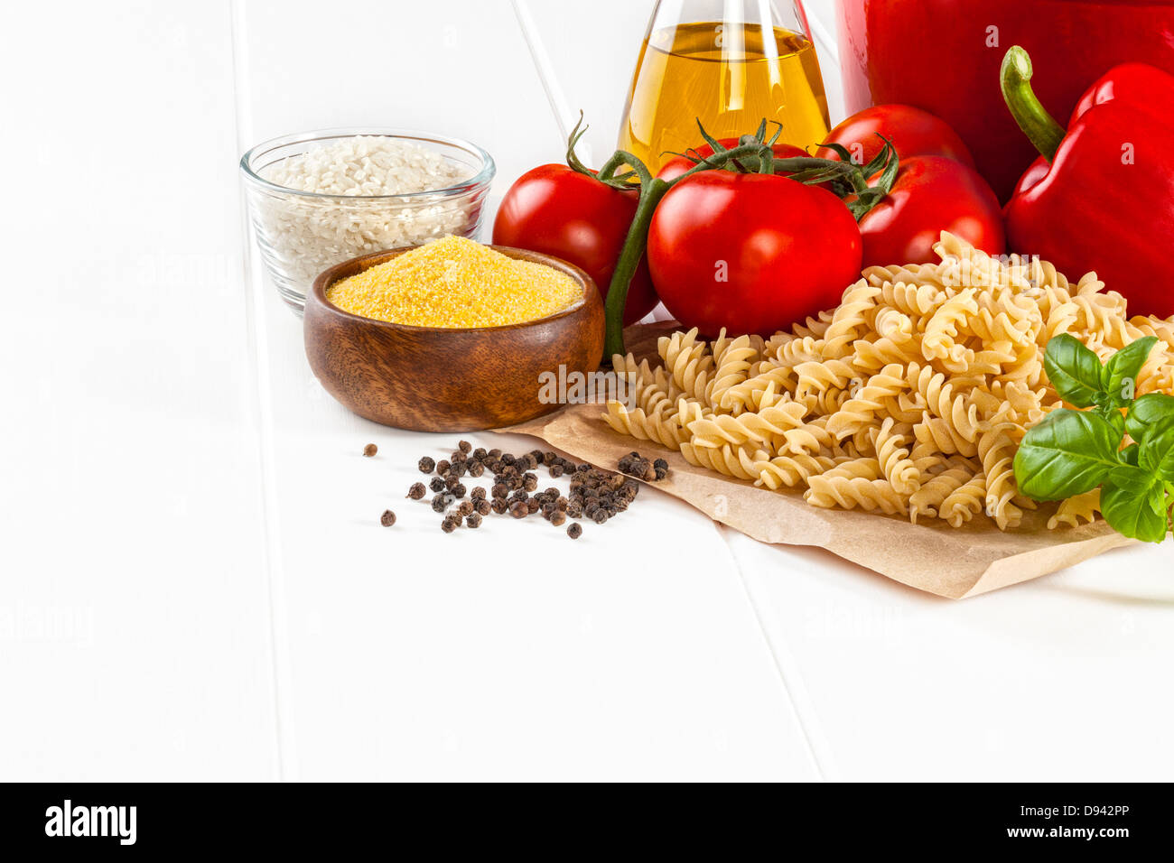 Il cibo italiano ingredienti - Ingredienti per la cucina italiana, basilico, bronzo morire fusili pasta peperoni rossi, pomodori, olio d'oliva... Foto Stock