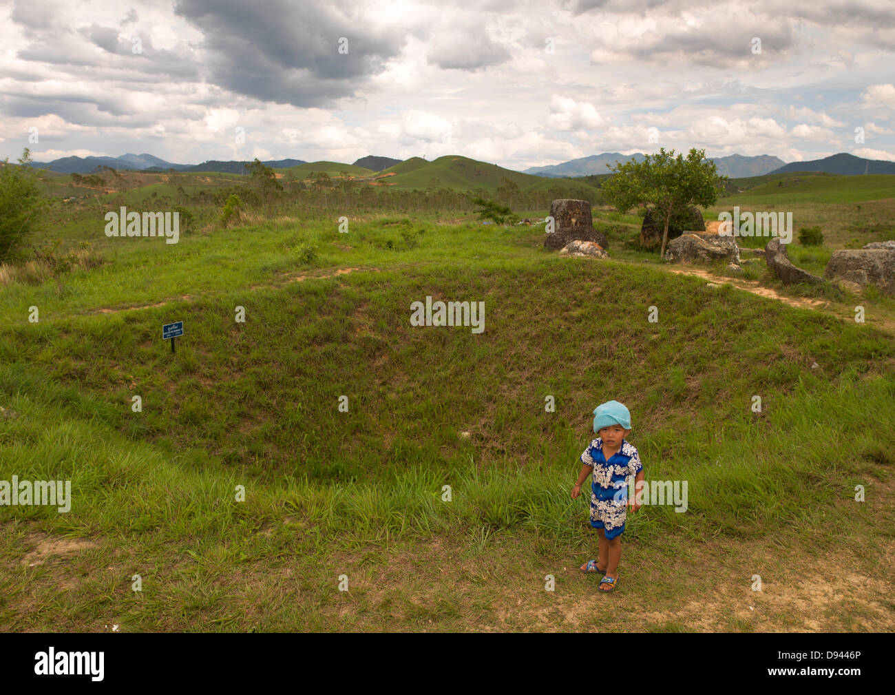 Bambino da un cratere di una bomba a Pianura di giare Phonsavan, Laos Foto Stock