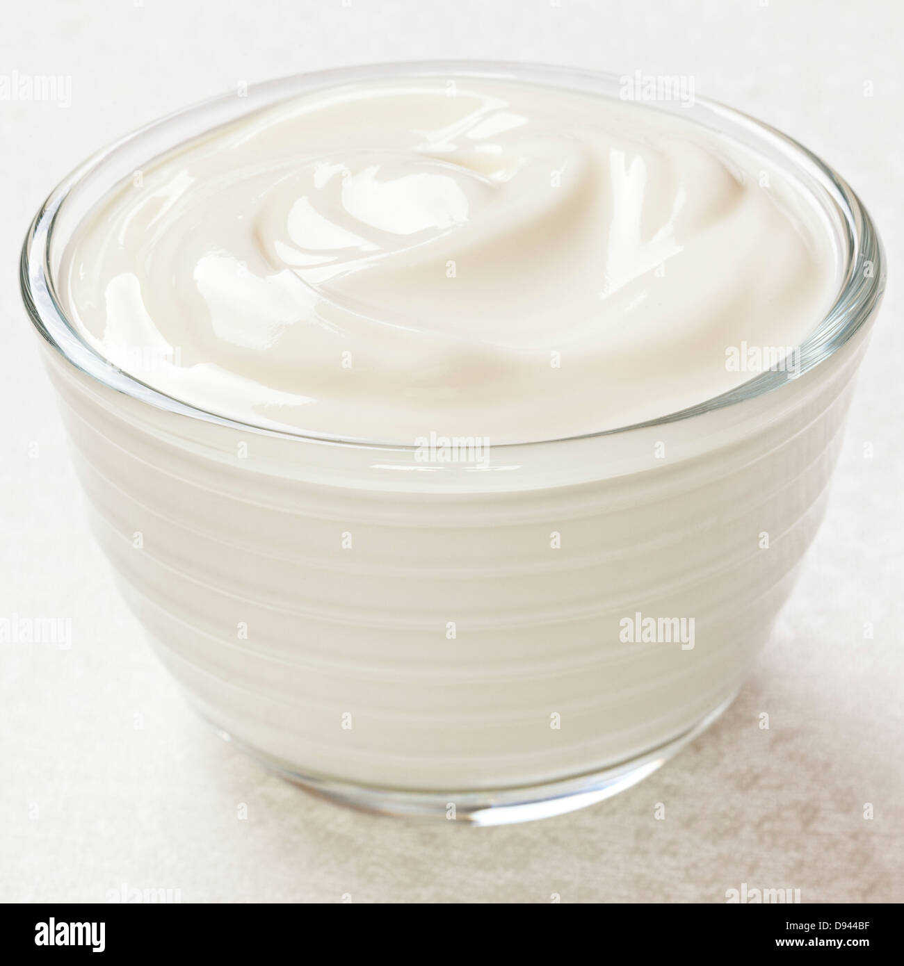 Yogurt - una piccola ciotola di yogurt bianco su uno sfondo luminoso. Foto Stock