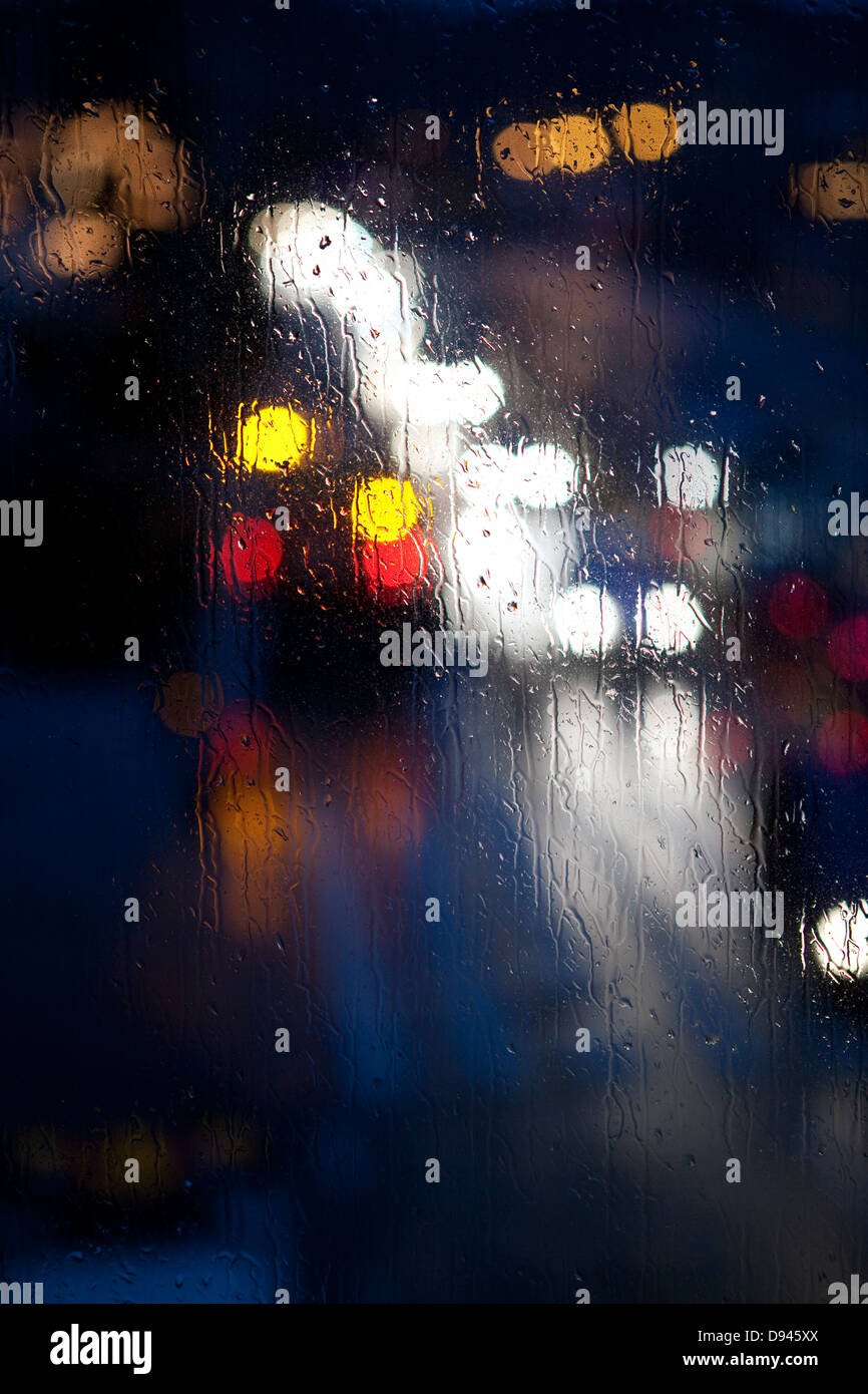 Le luci visto attraverso il vetro di pioggia Foto Stock