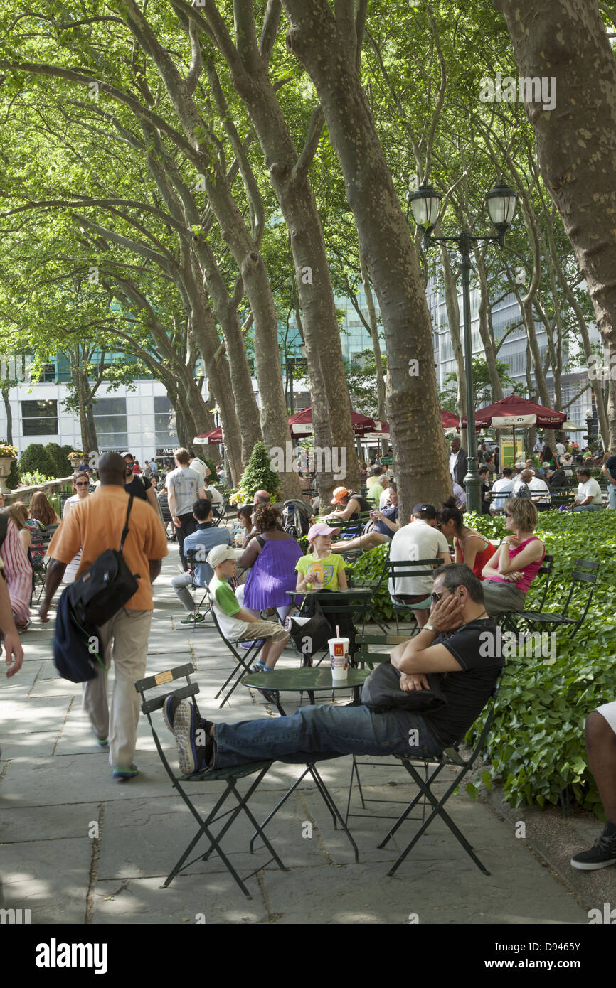 Le persone a rilassarsi in Bryant Park dietro la NY Public Library lungo 42nd Street in una calda giornata di primavera in midtown Manhattan, NY City Foto Stock