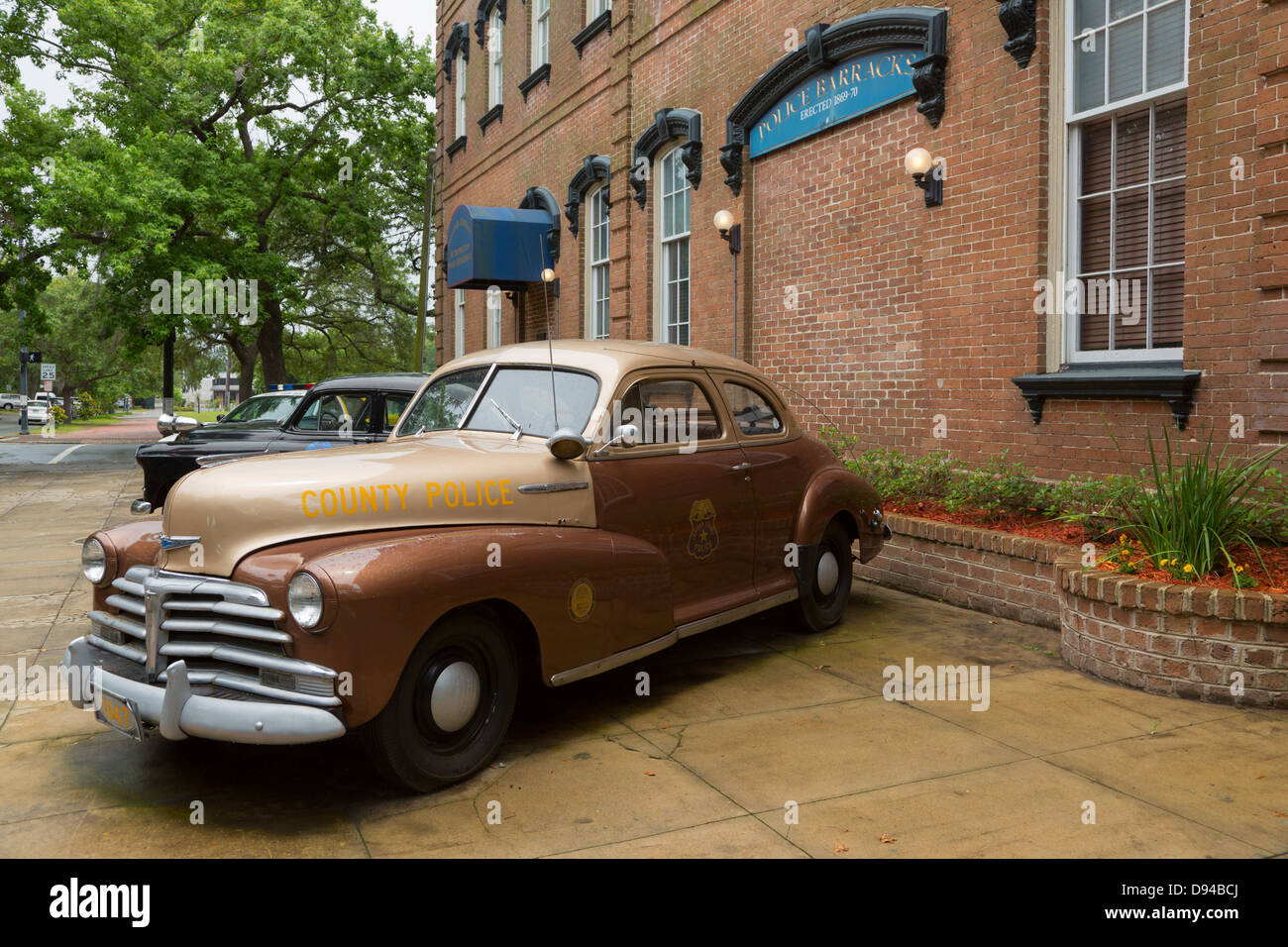 Vintage la polizia pattuglia delle vetture sul display al di fuori del centro storico di Savannah Chatham Metropolitan caserma di polizia edificio. Foto Stock