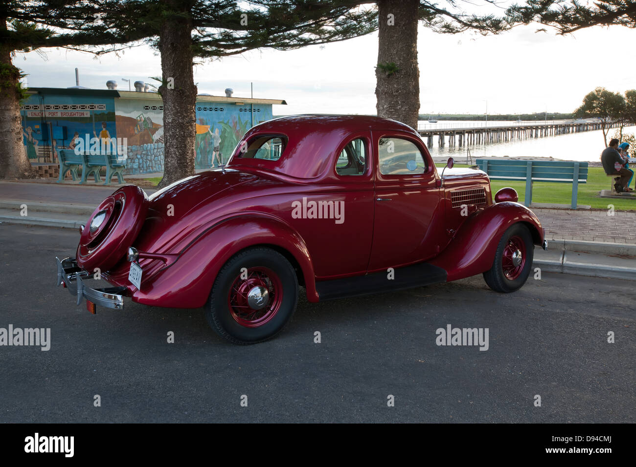 Vecchia auto rossa da giorni passati parcheggiato sul foreshore porto Broughton Foto Stock