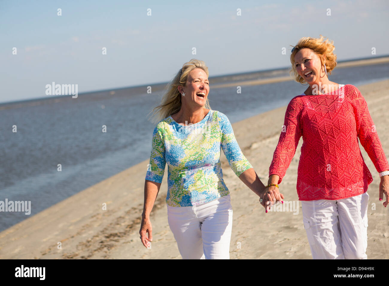 Donne caucasici camminando sulla spiaggia Foto Stock