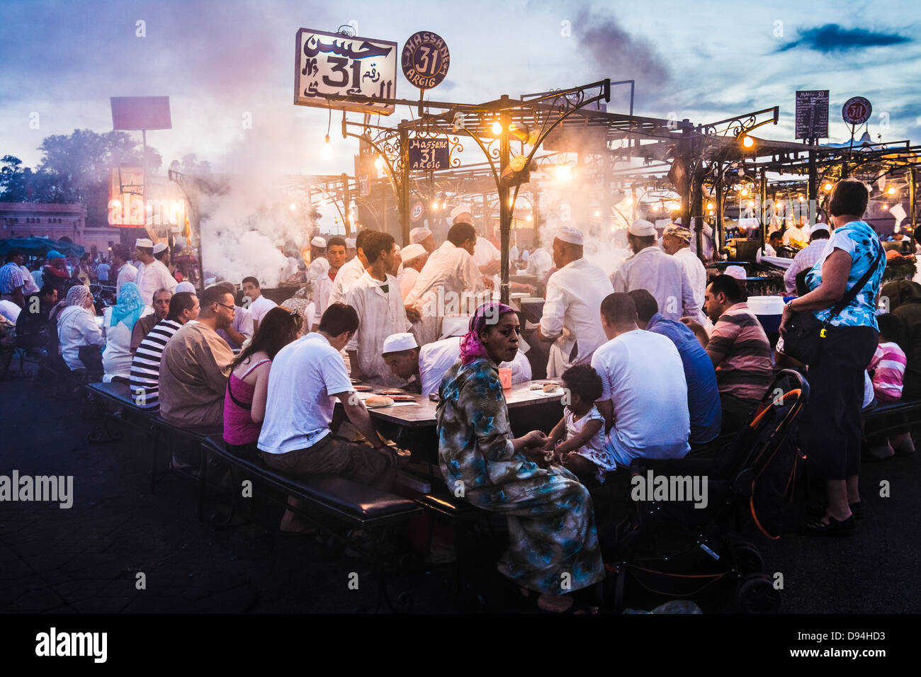 Djemaa el Fna. Persone cenare presso gli stand gastronomici si al tramonto. Marrakech, Marocco Foto Stock