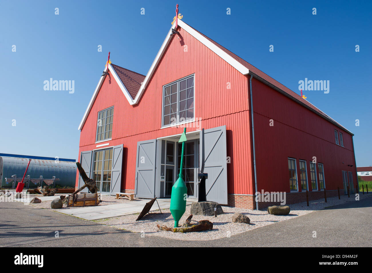 Rosso magazzini di legno nel villaggio olandese di Zoutkamp farai parte della barca di pescatori nella parte anteriore Foto Stock