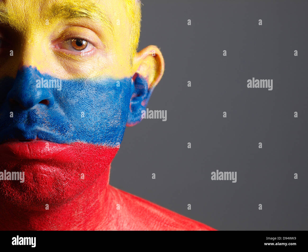 L'uomo faccia dipinta con bandiera colombiana. L'uomo è triste e composizione fotografica lascia solo metà della faccia. Foto Stock