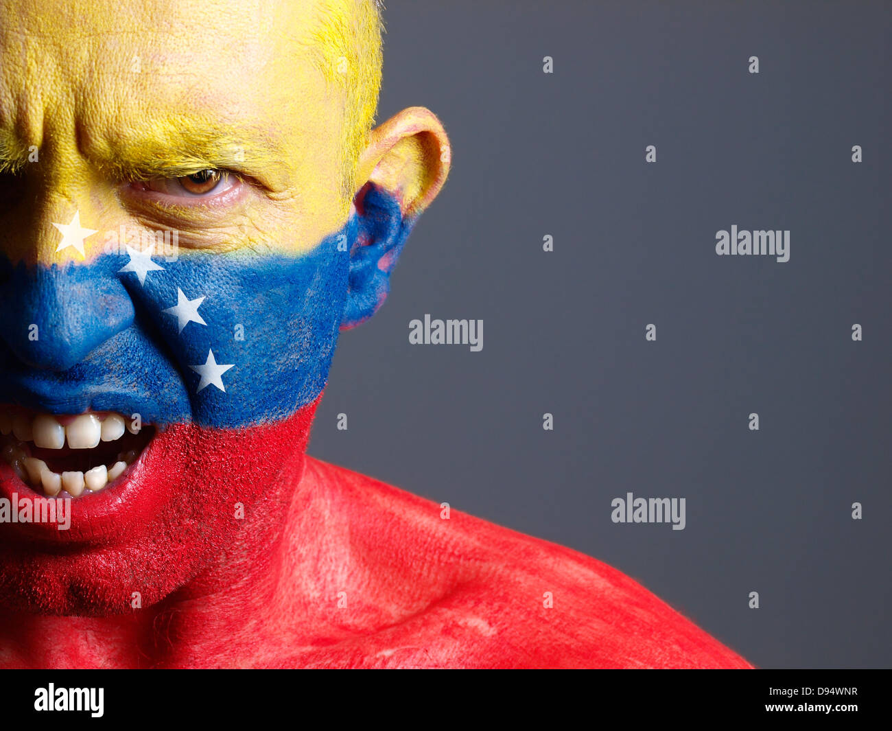 L'uomo faccia dipinta con bandiera venezuelana. L'uomo è arrabbiato e composizione fotografica lascia solo metà della faccia. Foto Stock