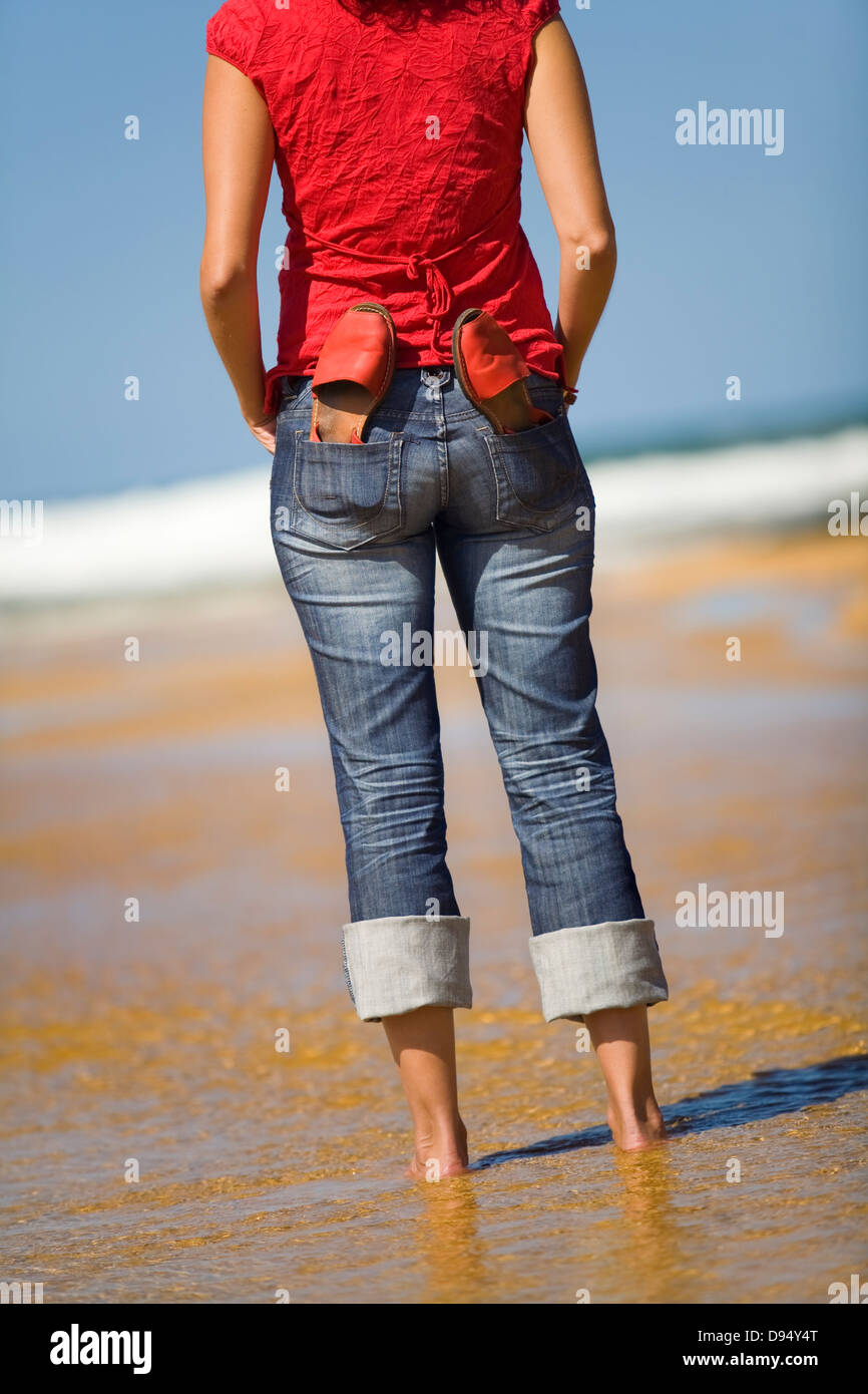 Ritratto di una giovane donna con un paio di sandali per la spiaggia Foto Stock