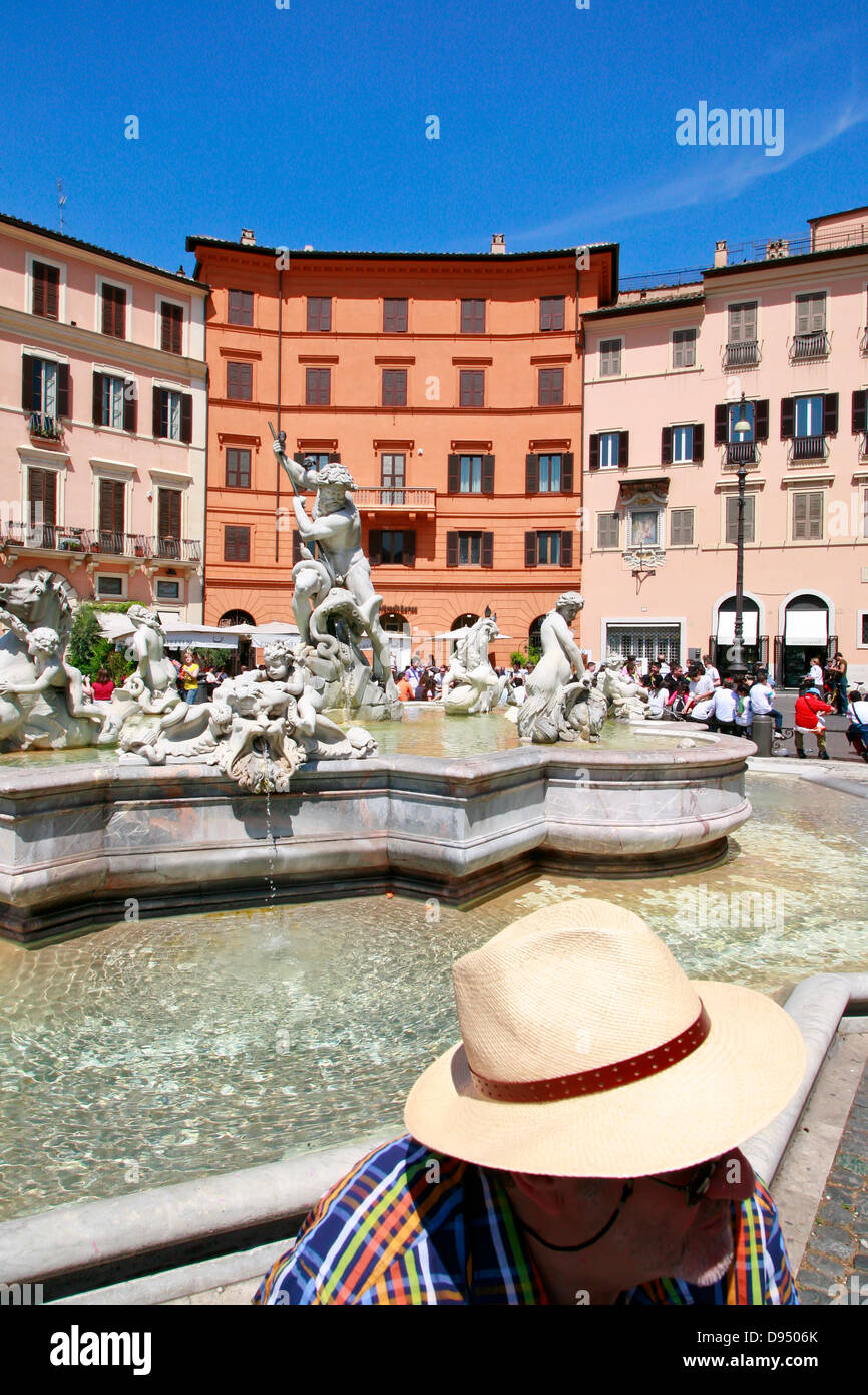 L uomo nel cappello di paglia di fronte alla fontana di Nettuno in Piazza Navona, Roma, Italia Foto Stock