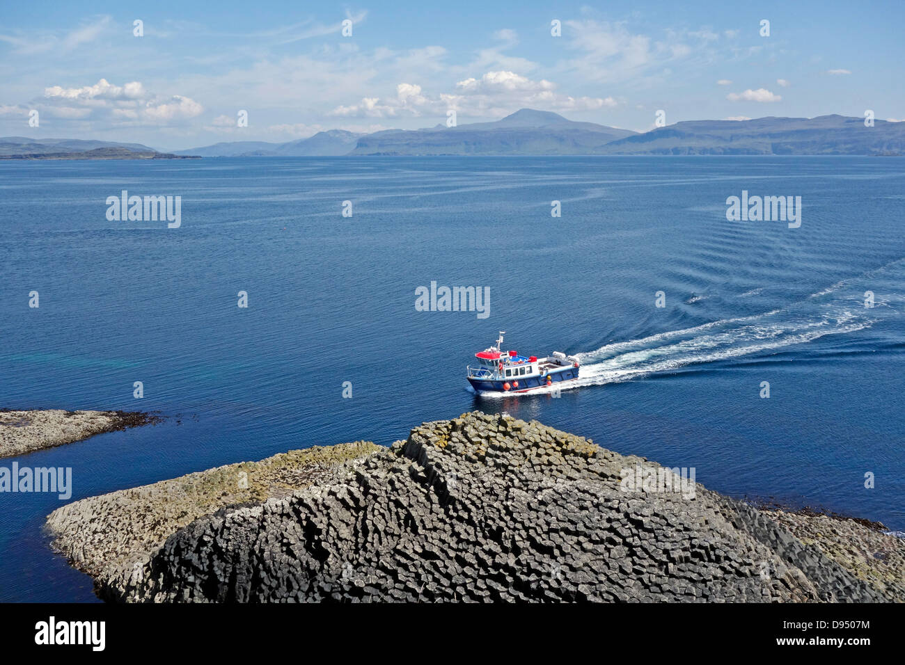 Imbarcazione a motore Ullin della staffa si avvicina al molo su isola di Staffa in Scozia per prelevare i passeggeri per il viaggio di ritorno. Foto Stock