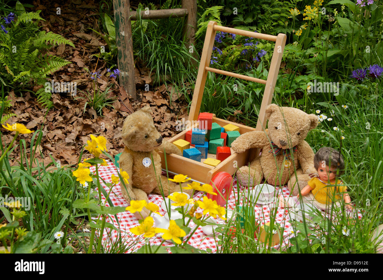 Tea party con i giocattoli in cosa dovremo lasciare? NSPCC Giardino di infanzia magico ad RHS Chelsea Flower Show 2013, Londra, Regno Unito. Foto Stock