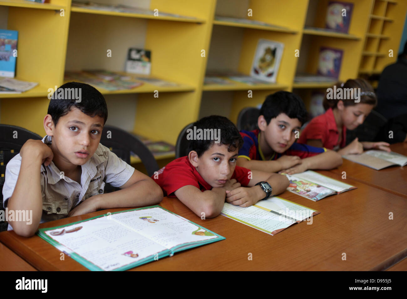 Giugno 11, 2013 - Gaza City, nella Striscia di Gaza, Territori palestinesi - bambini palestinesi leggere storie in un centro di intrattenimento durante le vacanze estive in Gaza City Giugno 11, 2013. Intrattenimento e istituzioni educative nella striscia di Gaza la messa a fuoco su varie attività per i bambini durante le vacanze che includono giochi, scrittura creativa, concorsi, proiezioni cinematografiche, narrazione e disegno libero (credito Immagine: © Ashraf Amra/immagini APA/ZUMAPRESS.com) Foto Stock