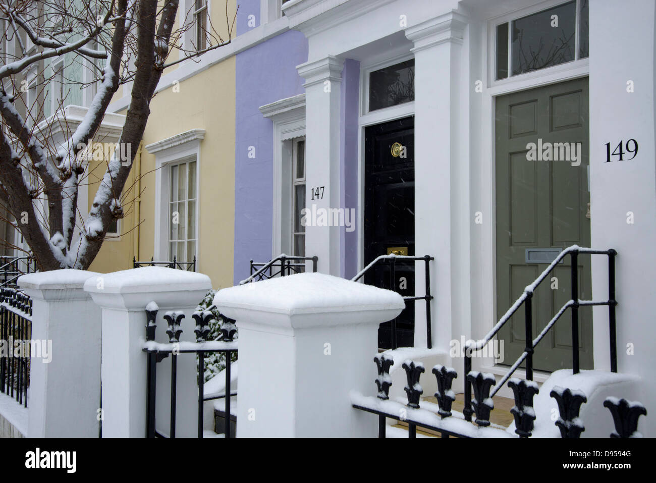 La caduta di neve nella parte anteriore del case color pastello a Notting Hill, Londra, Regno Unito Foto Stock