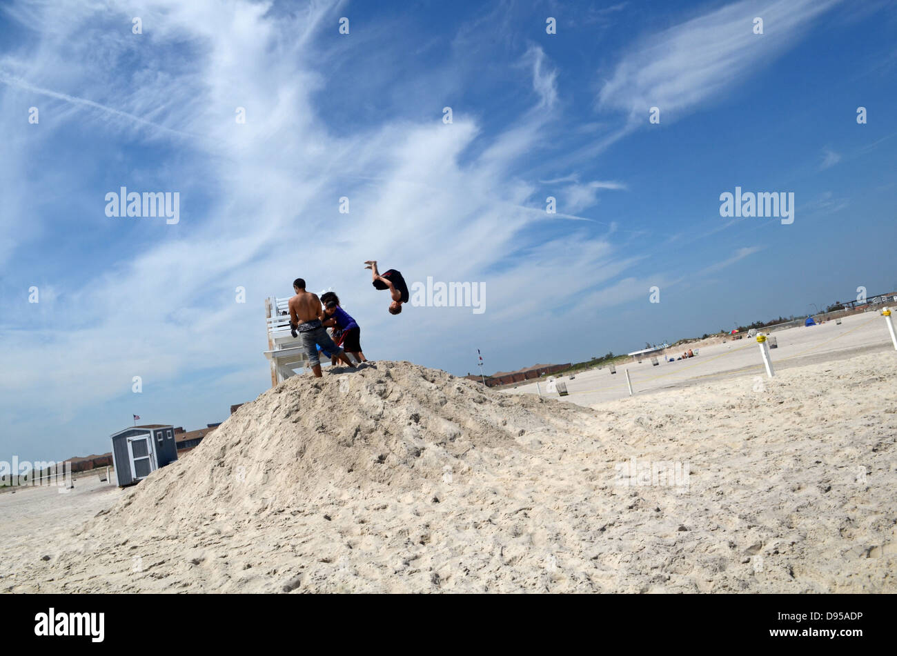 Giovane uomo compie il salto acrobatico su Jones Beach State Park, Nassau County, New York Foto Stock