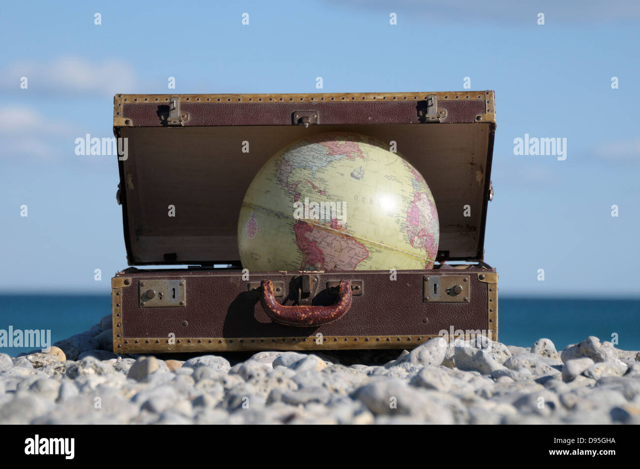 Globo in valigia sulla spiaggia rocciosa, Frontignan, Herault, Francia Foto Stock