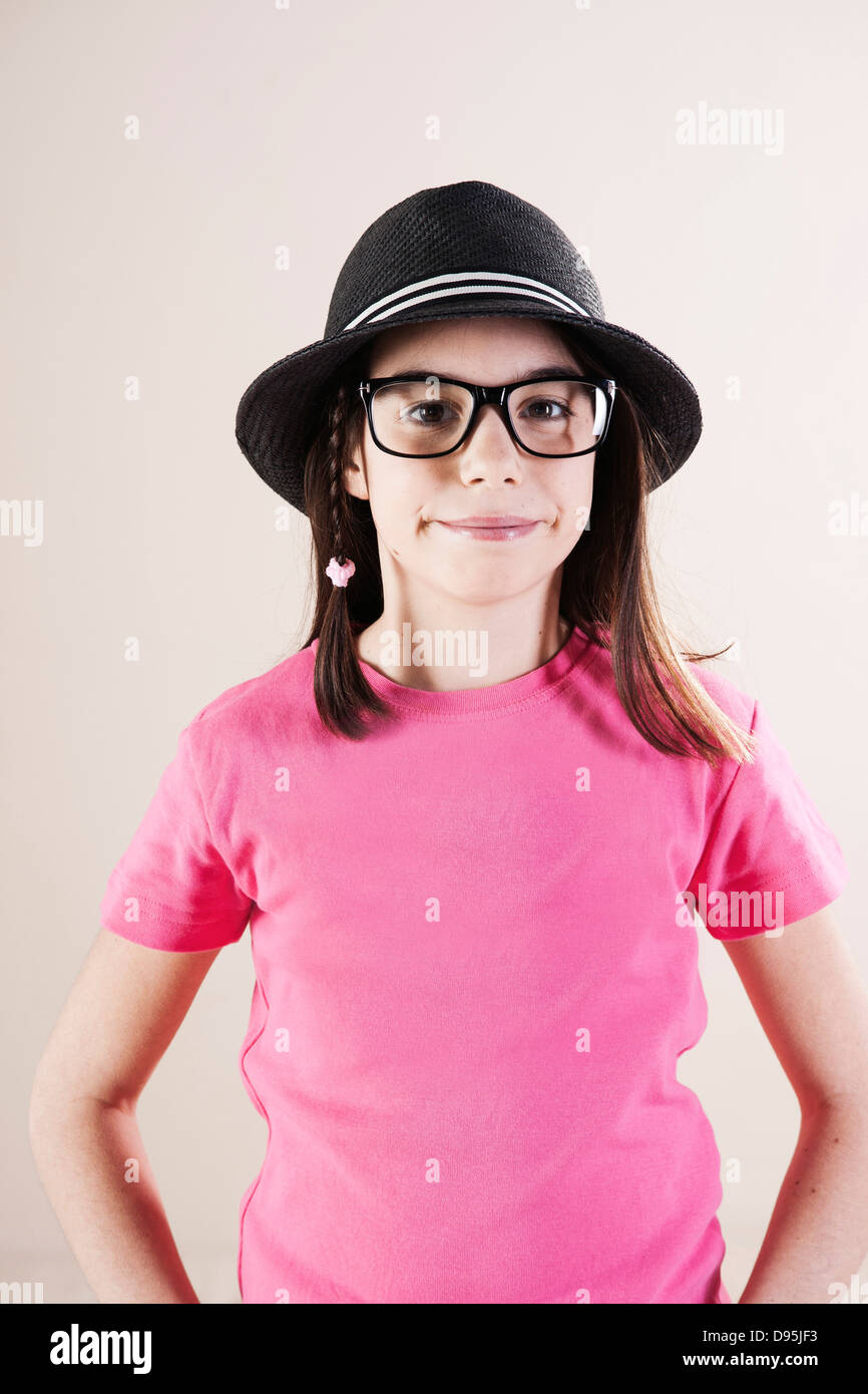 Ritratto di una ragazza che indossa Fedora e Horn-Rimmed occhiali, guardando la telecamera, Studio Shot Foto Stock