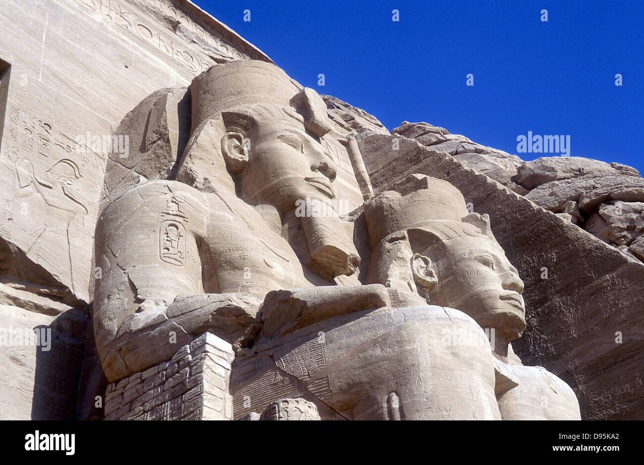20 metri di statue di Ramses II, righello di Egitto c1304-1273 BC, nella parte anteriore del tempio principale, Abu Simbel. Foto Stock