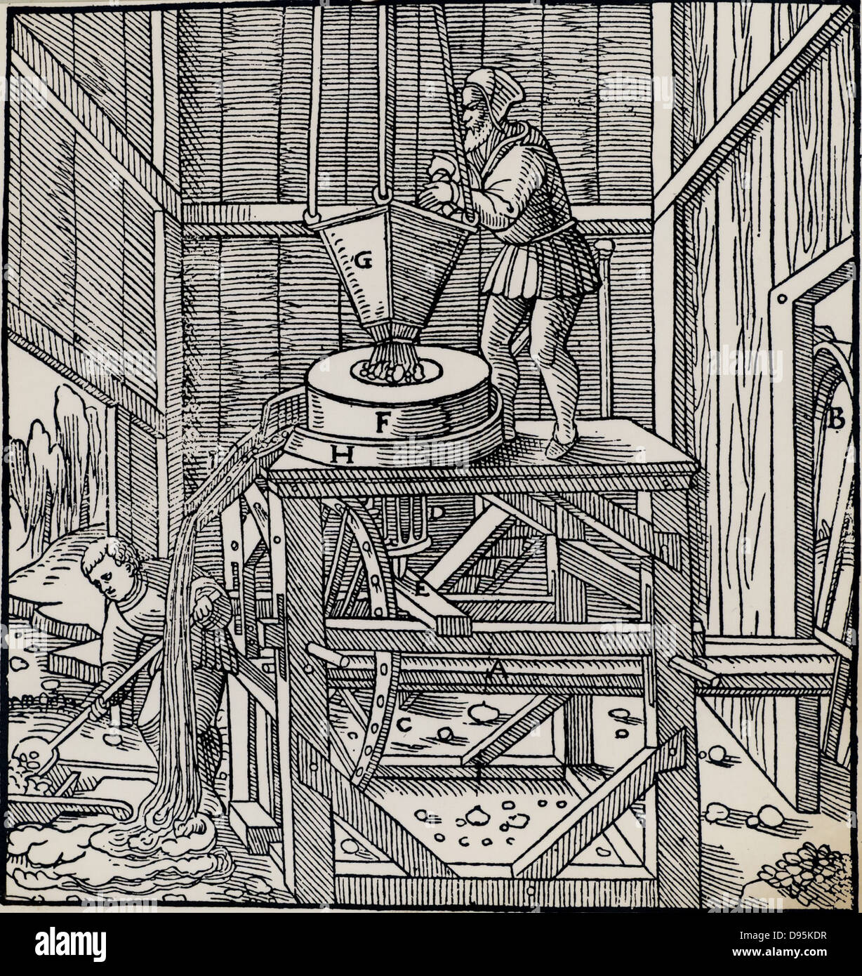 Minerale che è stato rotto in su in un mulino di timbratura essendo ulteriormente ridotto passando attraverso una macinazione mulino. Il mulino è azionato da una ruota di acqua, fuori del quadro a destra attraverso l'assale, A. raccontato e minerale di stagno sono stati trattati in questo modo. Da 'De re metallica', Agricola, pseudonimo di Georg Bauer (Basilea, 1556). Xilografia Foto Stock
