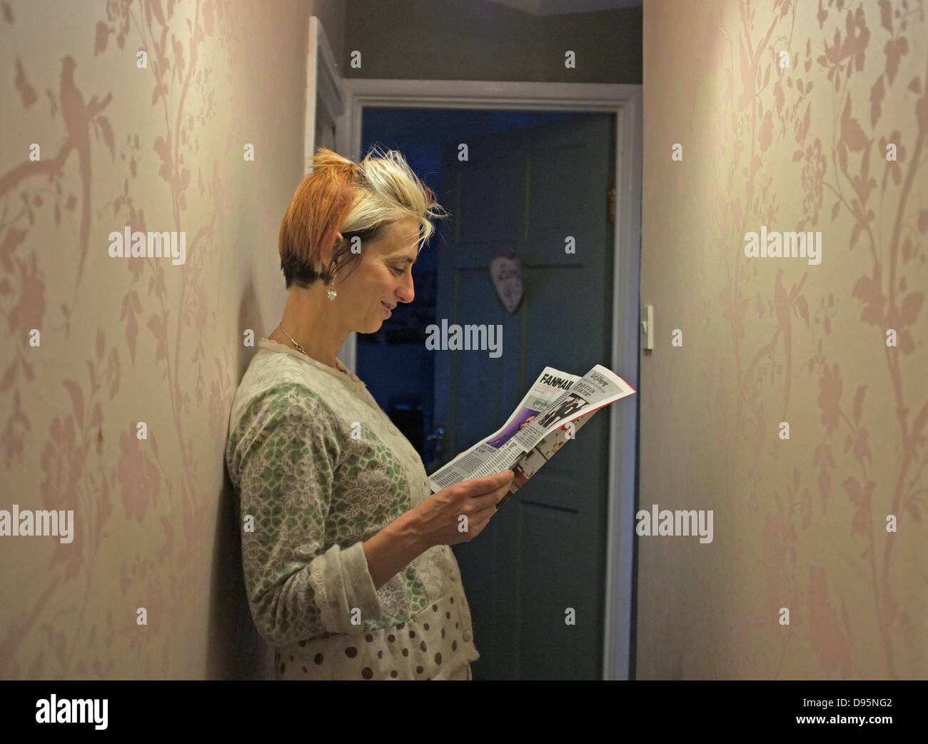 Una di mezza età, madre di tre figlie attende fuori la porta del bagno. Foto Stock