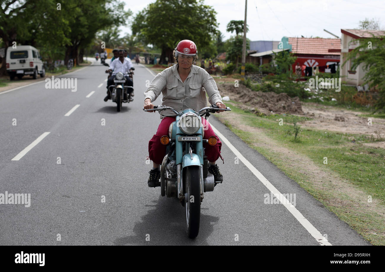 Donna europea alla guida di una royal Enfield sulle strade indiane Foto Stock