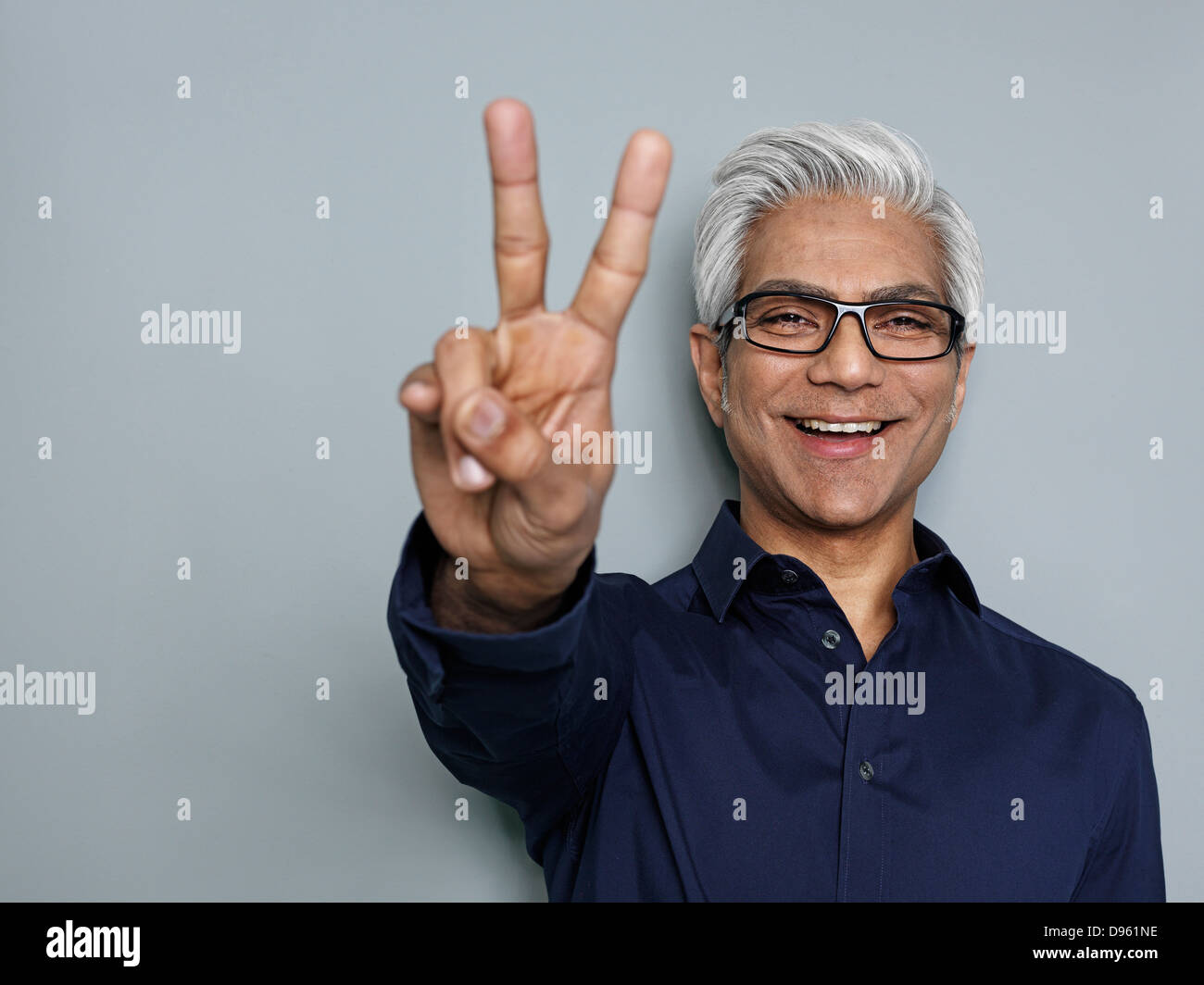 Imprenditore gesti segno di pace, sorridente Foto Stock