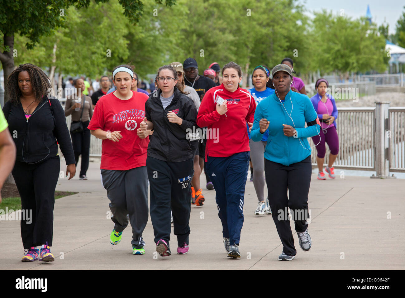 I giovani professionisti raccogliere lungo il Detroit Riverwalk per esercizio e networking. Foto Stock
