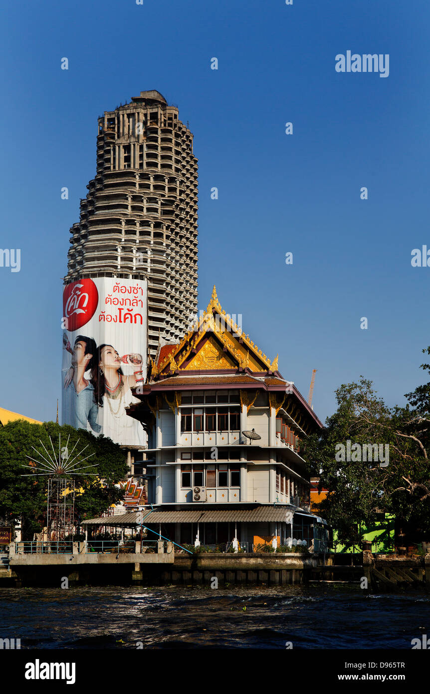 Coca cola pubblicità sul nuovo blocco a torre accanto alla tailandese tradizionale edificio sul fiume di Samphanthawong, Bangkok Foto Stock