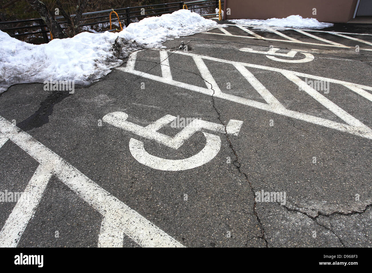 Sedia a rotelle il simbolo nel parcheggio e la neve in Giappone Foto Stock