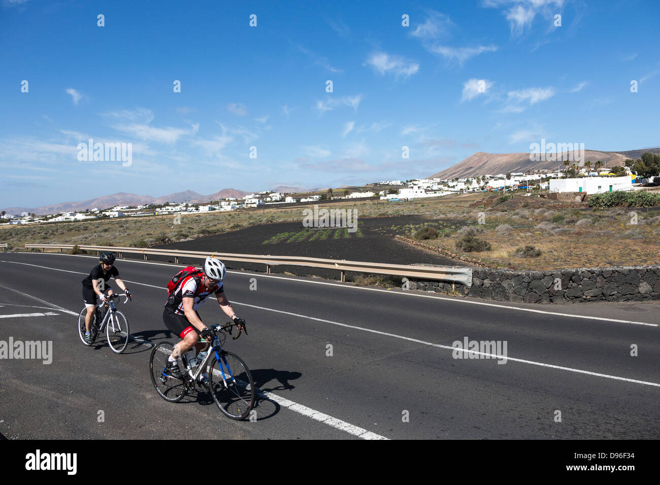 Ciclismo su strada attraverso il paesaggio vulcanico, Macher, Lanzarote, Isole Canarie, Spagna Foto Stock