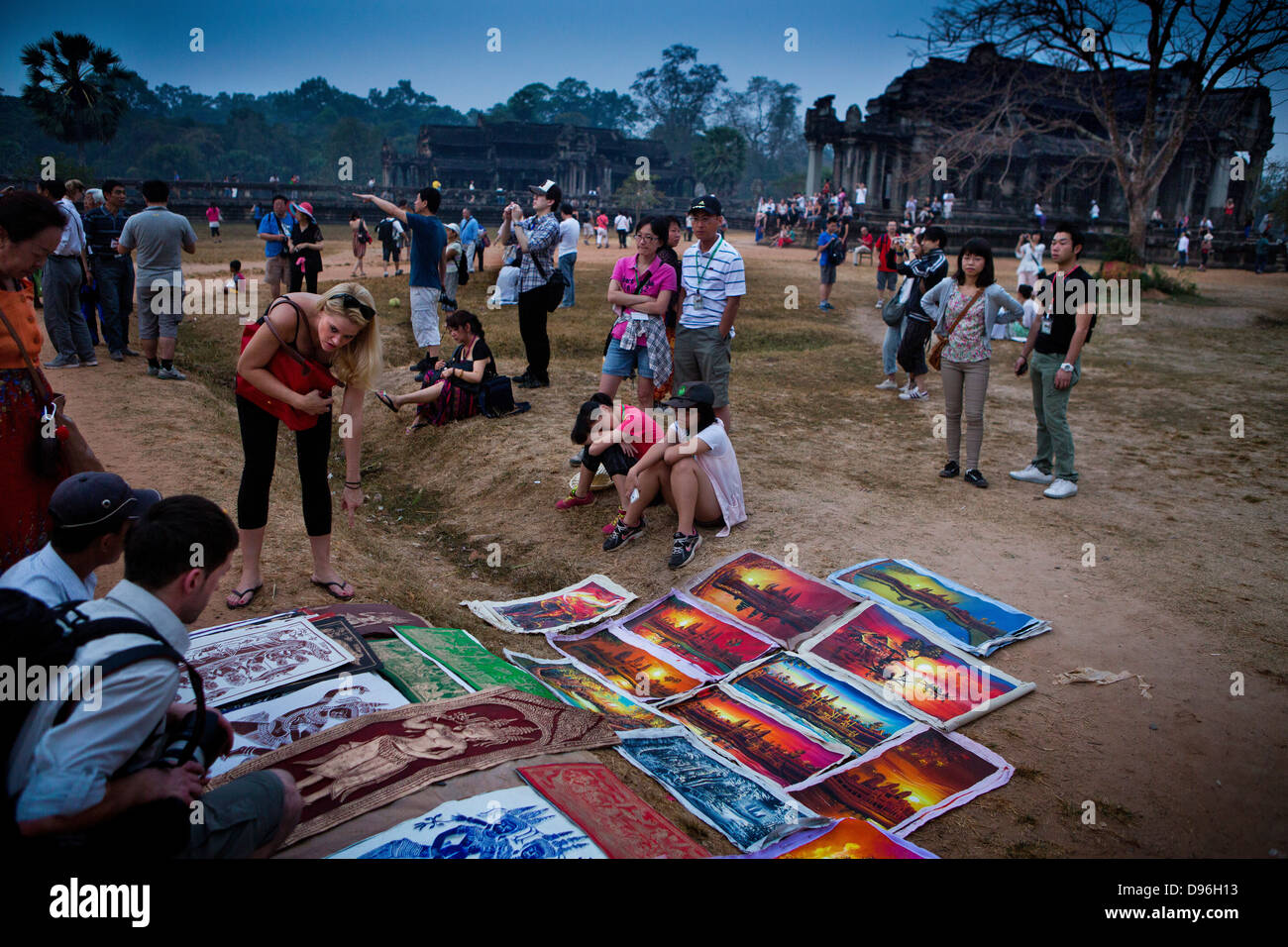 I turisti guardano artista locale di lavoro prima che l'alba in Angkor Wat in Cambogia Foto Stock