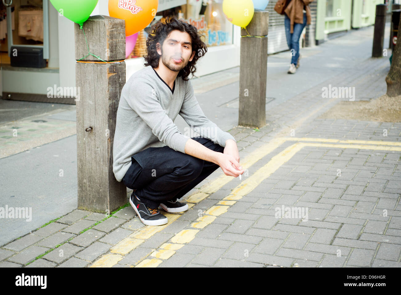 Un uomo fuma una sigaretta su Neal Street, Covent Garden di Londra. Foto Stock