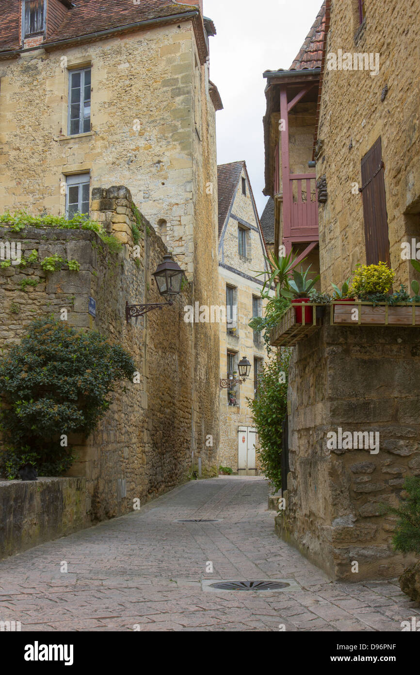 Incantevole borgo medievale di edifici di pietra arenaria lungo la stretta strada di ciottoli a Sarlat, Dordogne regione della Francia Foto Stock