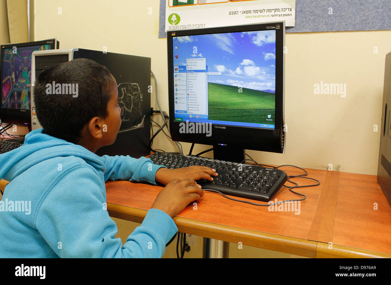 Bedouin boy utilizzando un computer presso un centro diurno in Tirabin al-Sana villaggio costruito per la trib Tarabin noto anche come Al-Tirabin situato nel deserto del Negev nel sud di Israele Foto Stock