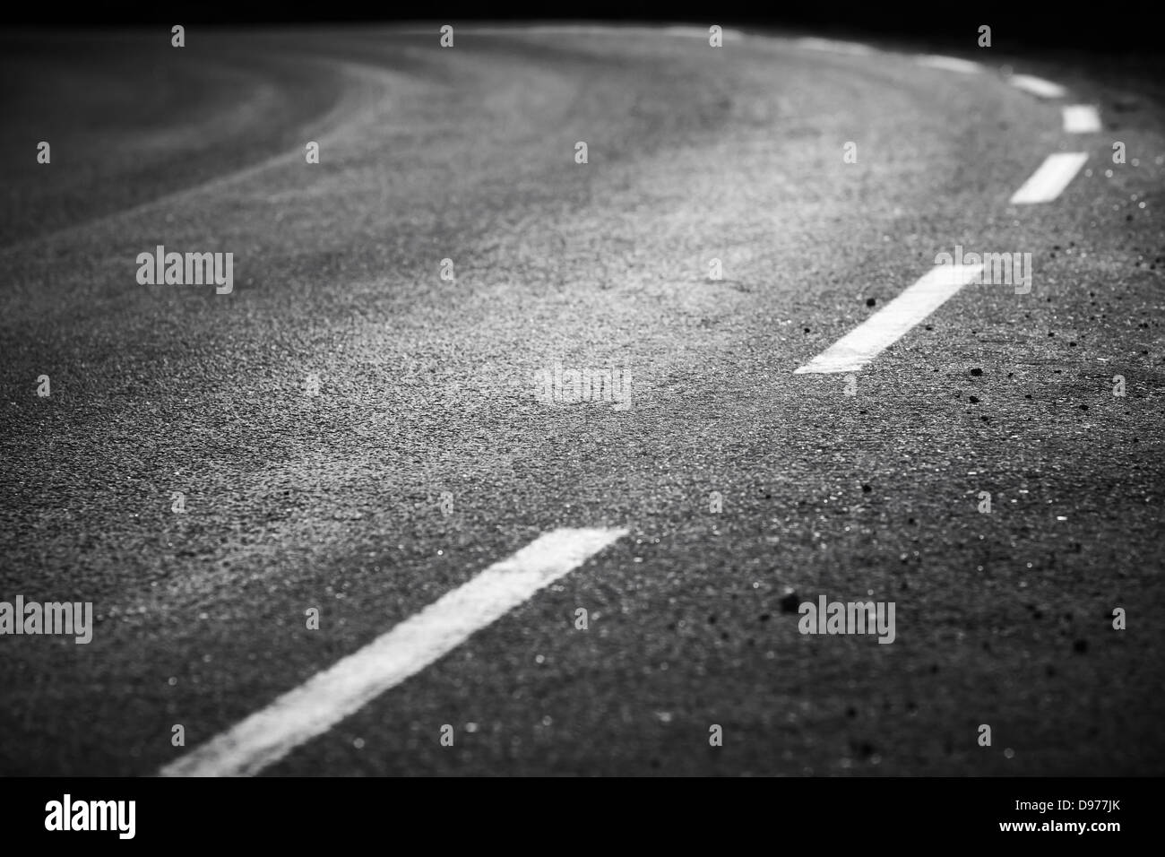 Girando strada asfaltata con linee di marcatura e tracce di pneumatici. Close up foto con messa a fuoco selettiva Foto Stock