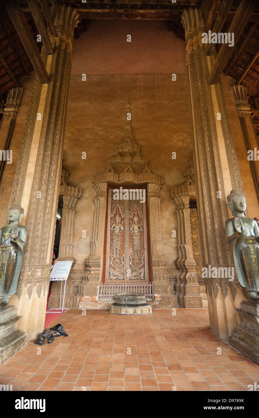 Vista verticale del buddha statue che ornano l'ingresso al Wat Ho Phra Keo o il Tempio del Buddha di Smeraldo di Vientiane. Foto Stock