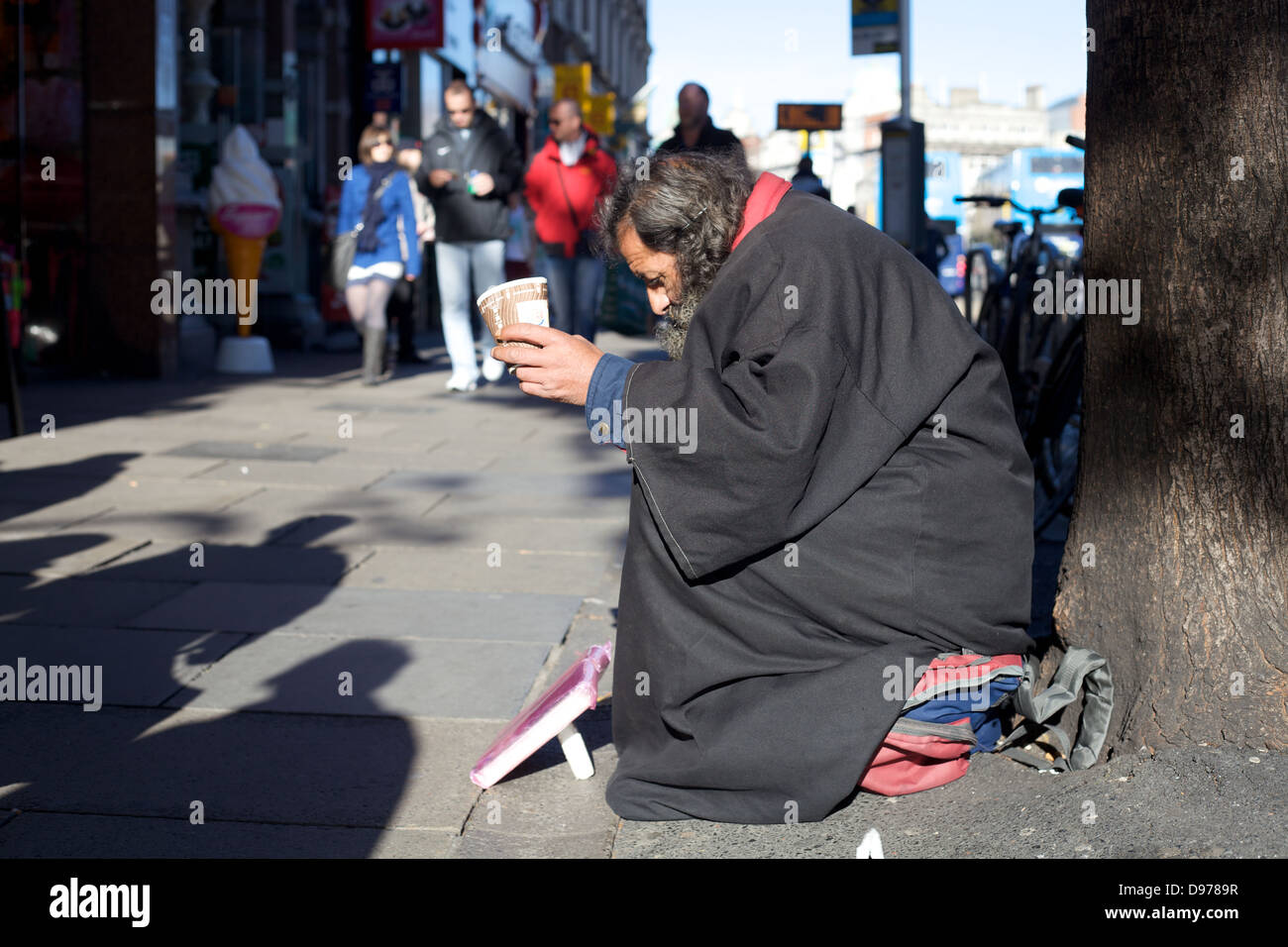 Un uomo senza tetto per l'accattonaggio denaro per le strade della città di Dublino, Irlanda Foto Stock