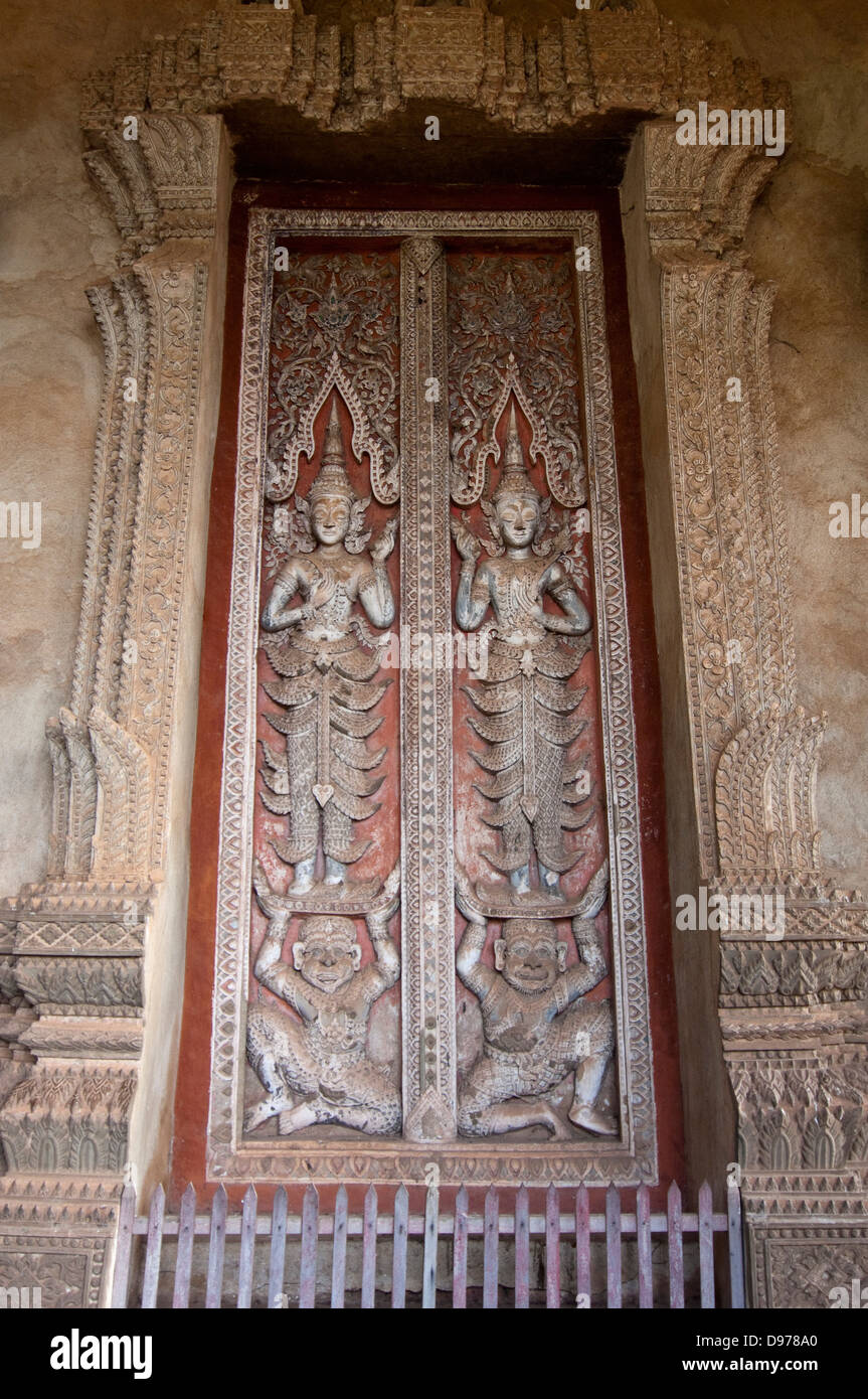 Chiudere verticale di legno intagliato porta all'entrata di Wat Ho Phra Keo o il Tempio del Buddha di Smeraldo di Vientiane Foto Stock