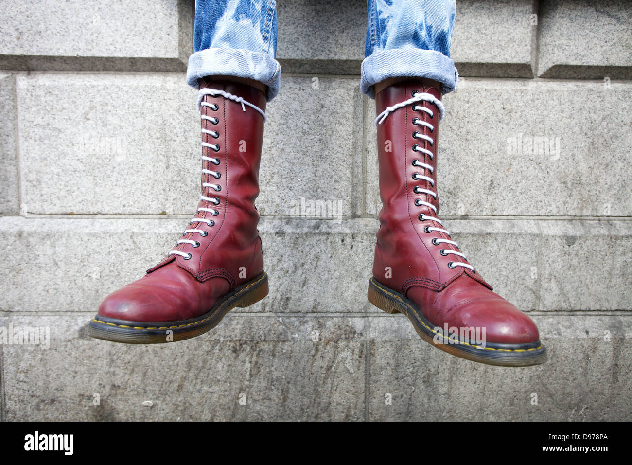 Un giovane che indossa un paio di stivali Bordeaux del dottor Martens. Foto Stock