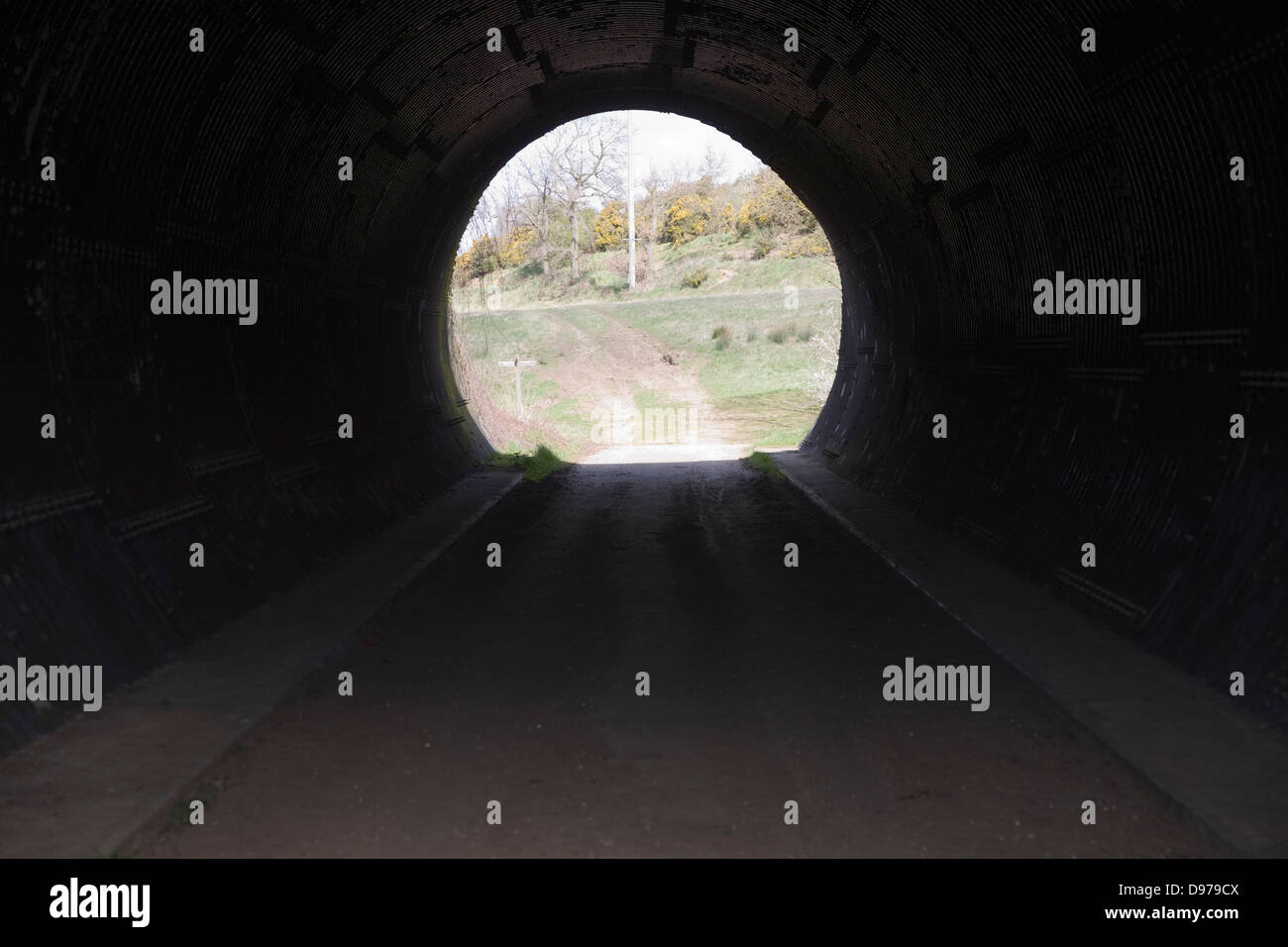 Visualizzare tramite il tunnel rivestito in ferro corrugato con luce alla fine Foto Stock