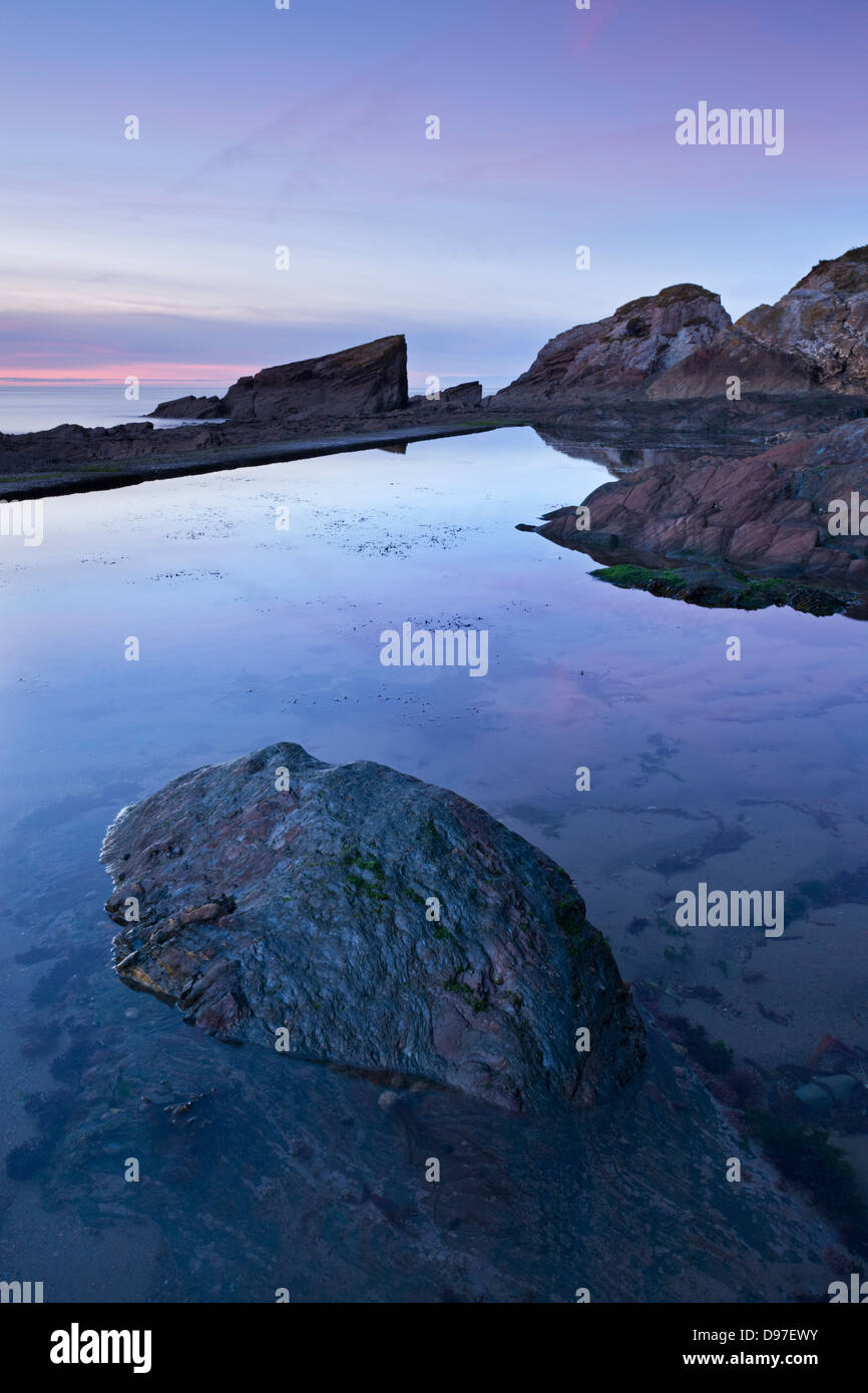 Twilight oltre le sponde rocciose di Combe Martin, Exmoor, Devon, Inghilterra. Foto Stock