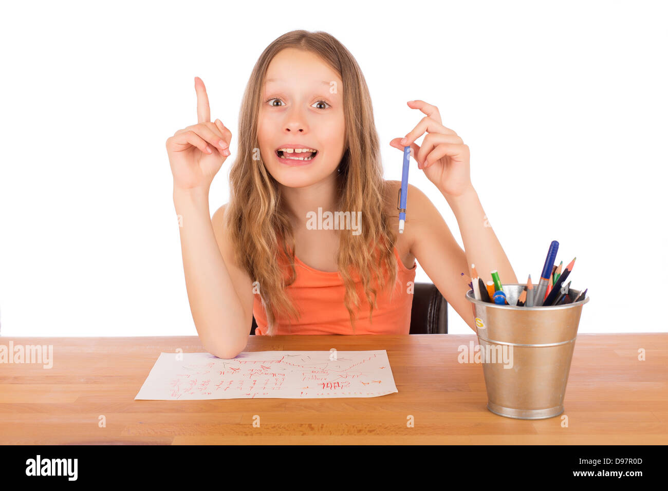 Bambino seduto a un tavolo trovato un idea per disegnare. Isolato su uno sfondo bianco. Foto Stock