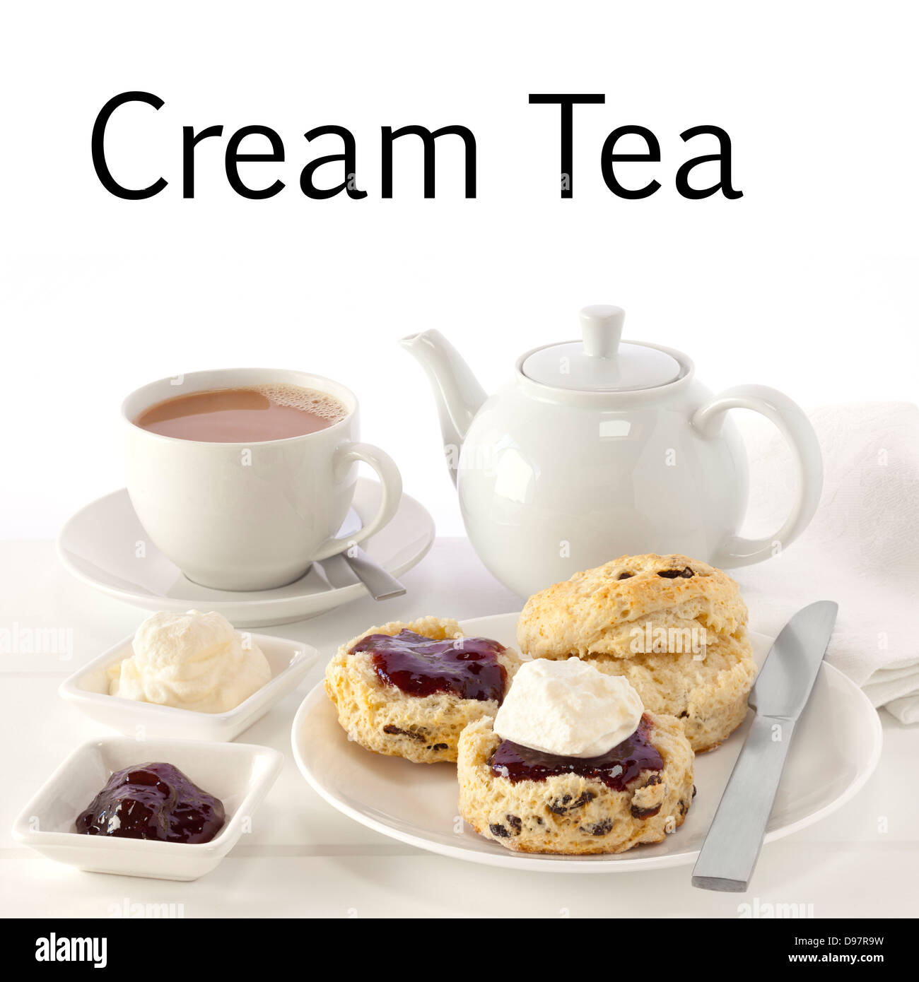 Tè alla crema - scones con marmellata e crema, servito con una tazza di tè e le parole tè alla crema. Questa immagine... Foto Stock