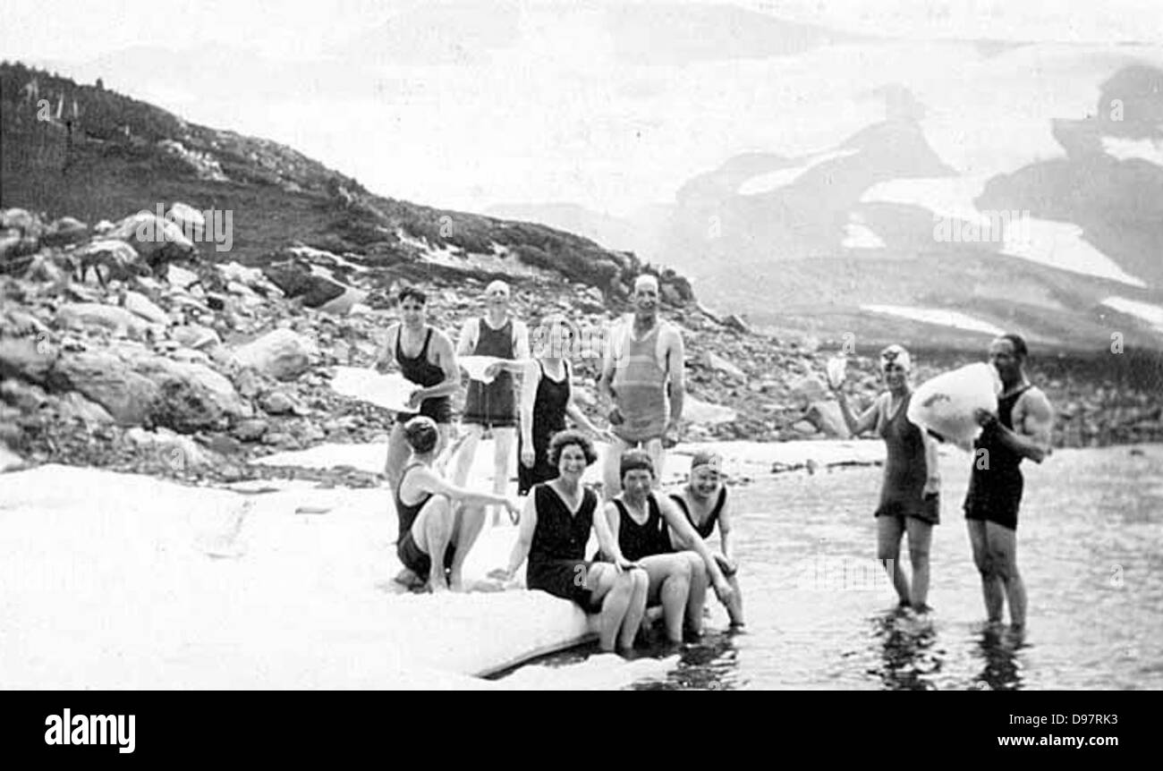 Un gruppo di alpinisti che si godono un'escursione estiva intorno al Monte Rainier a Washington, tra cui attività come nuotare nei laghi di montagna e nuotare in costume da bagno. Foto Stock