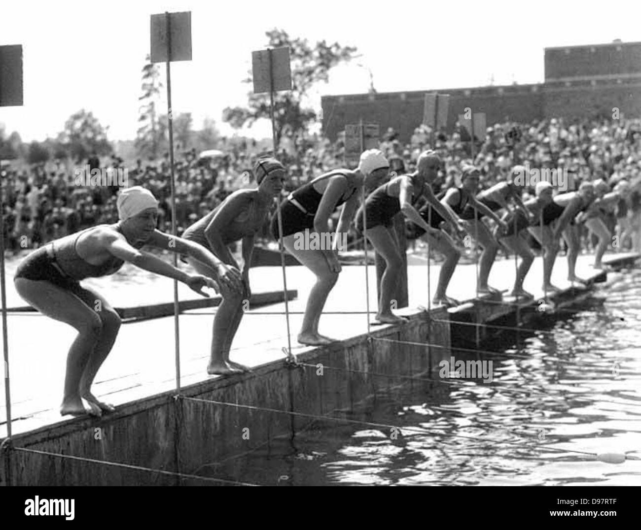 Dieci nuotatori allineando per avviare una gara al Lago Verde mentre una folla di orologi, Seattle, Washington Foto Stock