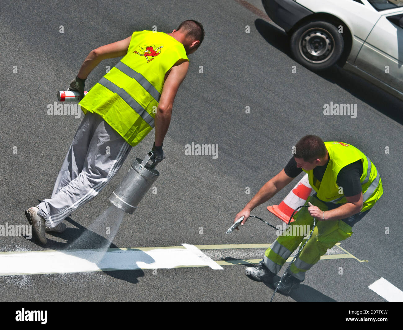 Consiglio lavoratori spruzzando la linea bianca sulla strada - Francia. Foto Stock