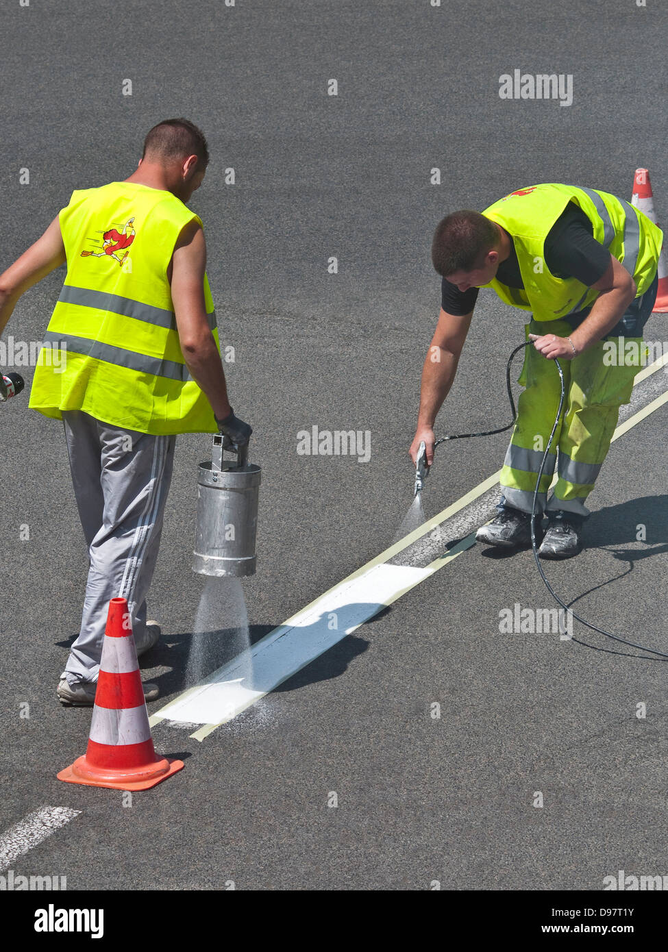 Consiglio lavoratori spruzzando la linea bianca sulla strada - Francia. Foto Stock