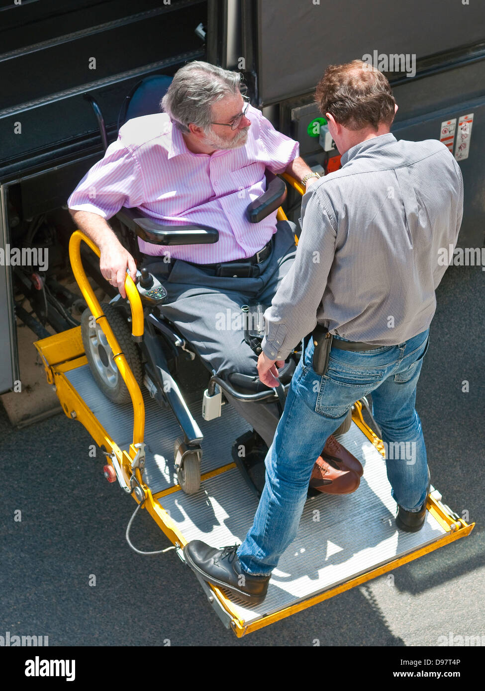 Vista aerea del uomo disabili in carrozzella essendo aiutato su pullman turistico ramp - Francia. Foto Stock