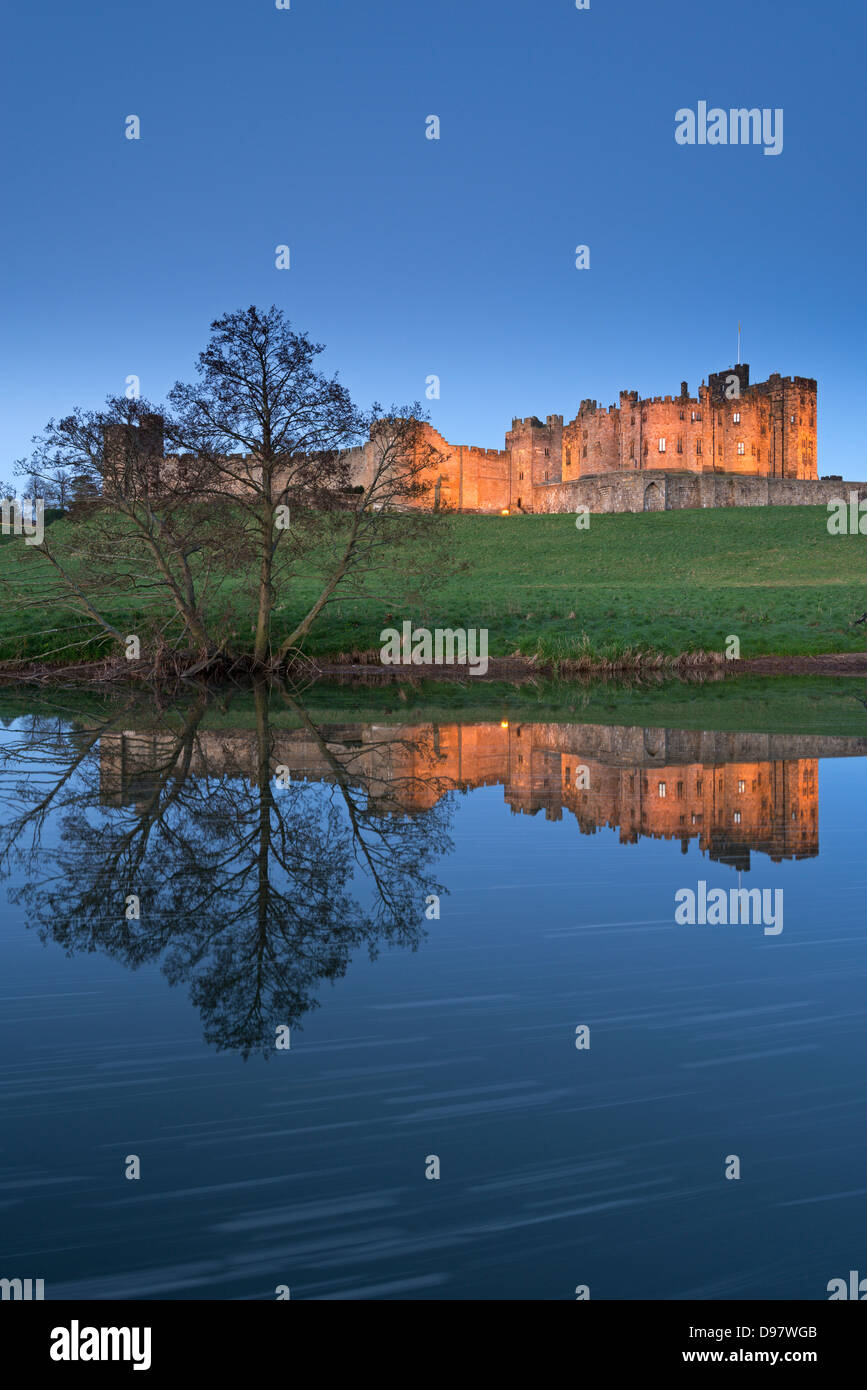 Alnwick Castle riflessa nel fiume Aln al crepuscolo, Northumberland, Inghilterra. Molla (maggio) 2013. Foto Stock