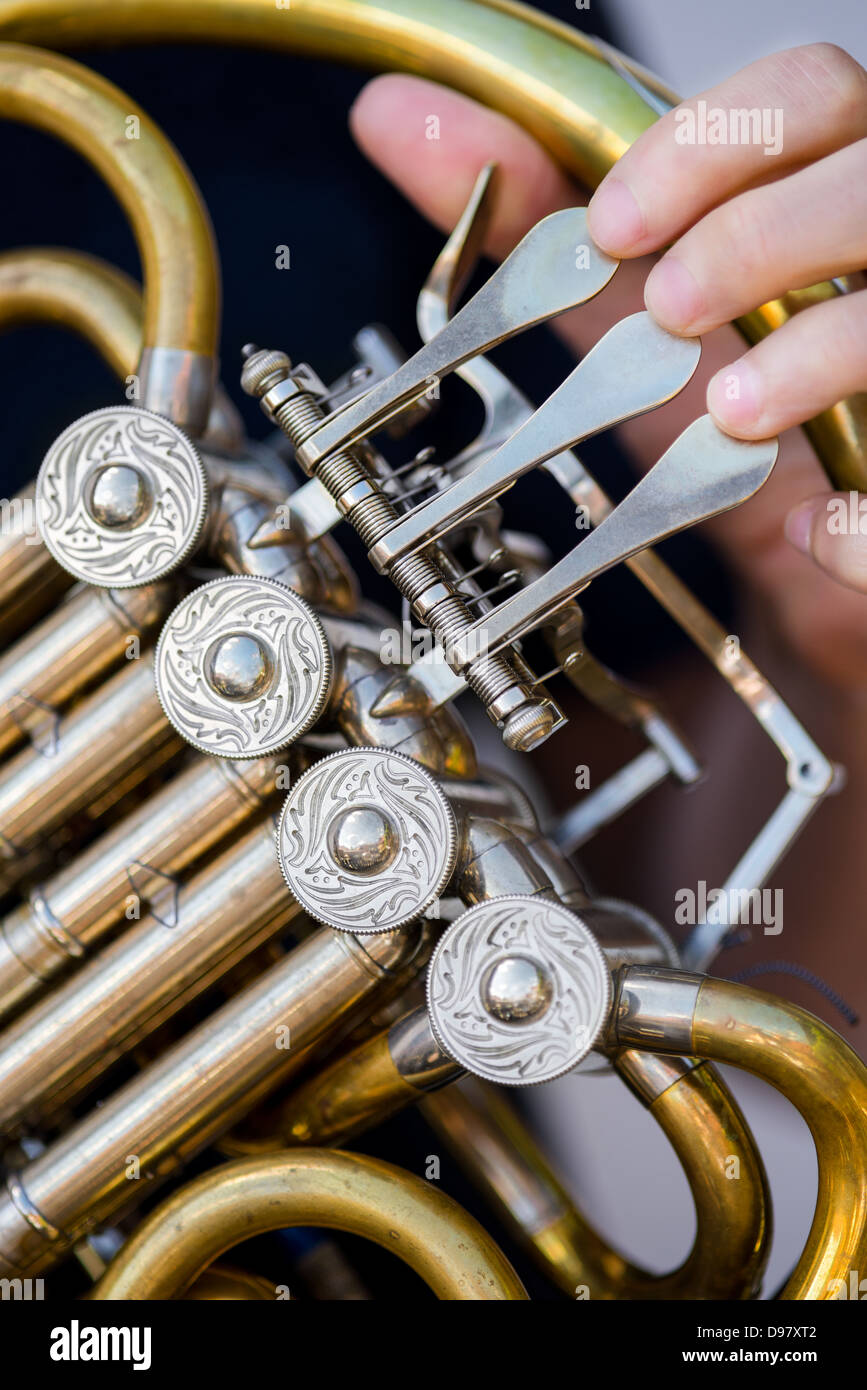 Maschio caucasico suonatore di corno di rotori di contenimento sul suo vecchio golden corno francese Foto Stock